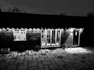a house with lights on the front of it at Walnut Tree Cottage Barn in Toppesfield