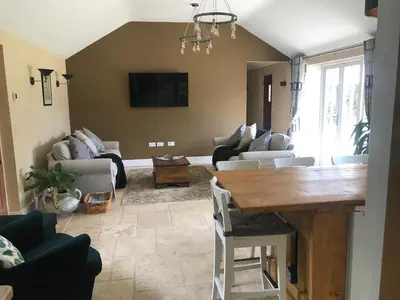 a living room with a table and a couch at Walnut Tree Cottage Barn in Toppesfield