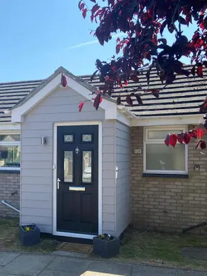 a house with a black door and a window at Modern and spacious open plan bungalow in Felixstowe