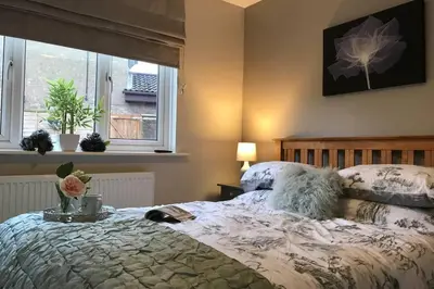 a bedroom with a bed and a window at Modern and spacious open plan bungalow in Felixstowe