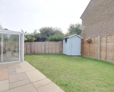 a backyard with a fence and a shed at Modern and spacious open plan bungalow in Felixstowe
