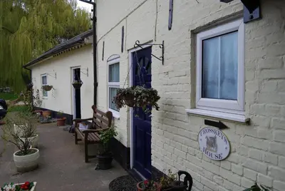 a blue door on the side of a building at Cottage - Sleeps 3 Parking & Fishing in Hilgay