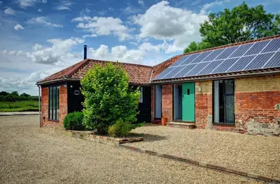 a house with solar panels on the roof at East Green Farm Cottages - The Old Stables in Saxmundham