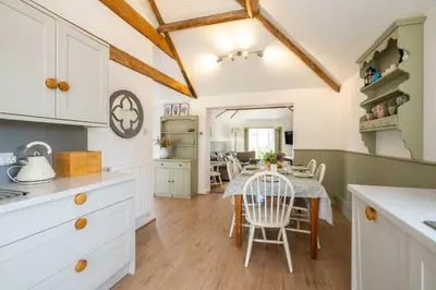 a kitchen and dining room with a table and chairs at East Green Farm Cottages - The Old Stables in Saxmundham