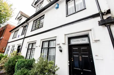 a white building with a black door with a sign on it at NEW Bespoke 2 BED Town Centre Serviced Apartment in Ipswich