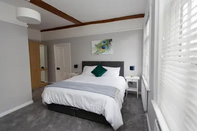 a bedroom with a large bed with white sheets at NEW Bespoke 2 BED Town Centre Serviced Apartment in Ipswich