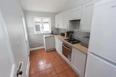a kitchen with white cabinets and a tile floor at NEW Bespoke 2 BED Town Centre Serviced Apartment in Ipswich