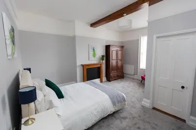 a bedroom with a large bed and a door at NEW Bespoke 2 BED Town Centre Serviced Apartment in Ipswich
