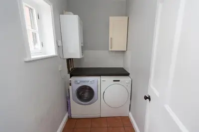 a small laundry room with a washing machine and a window at NEW Bespoke 2 BED Town Centre Serviced Apartment in Ipswich