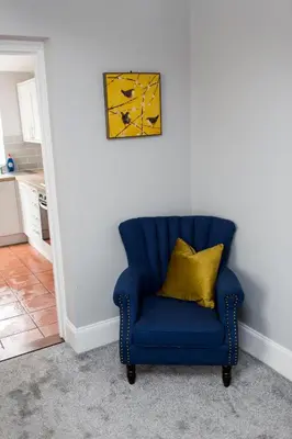 a blue chair with a yellow pillow in a kitchen at NEW Bespoke 2 BED Town Centre Serviced Apartment in Ipswich