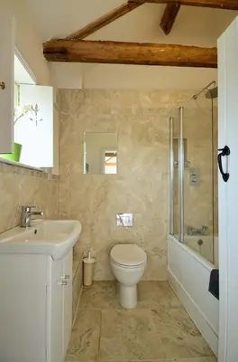 a bathroom with a toilet and a sink and a shower at East Green Farm Cottages - The Granary in Saxmundham