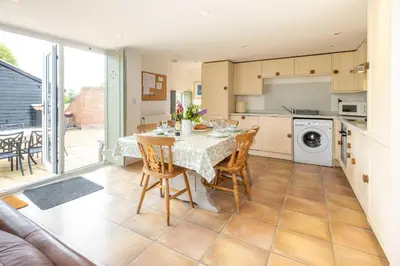 a kitchen and dining room with a table and chairs at East Green Farm Cottages - The Dairy in Saxmundham