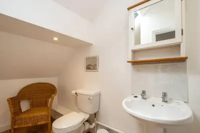 a bathroom with a toilet and a sink at East Green Farm Cottages - The Dairy in Saxmundham