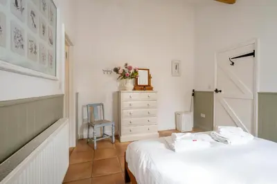 a bedroom with a bed and a dresser and a chair at East Green Farm Cottages - Gardeners Cottage in Saxmundham