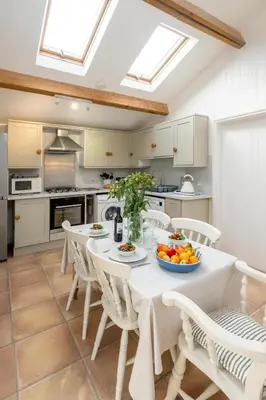 a kitchen with a table with a bowl of fruit on it at East Green Farm Cottages - Gardeners Cottage in Saxmundham