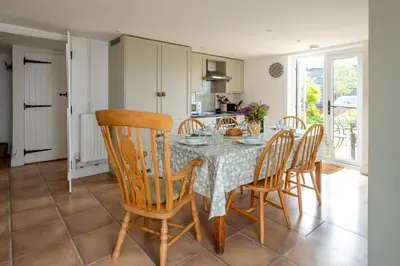 a kitchen and dining room with a table and chairs at East Green Farm Cottages - The Hayloft in Saxmundham