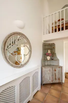 a mirror on the wall in a room with a table at East Green Farm Cottages - The Hayloft in Saxmundham