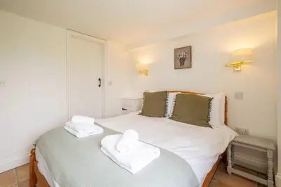 a bedroom with a bed with two towels on it at East Green Farm Cottages - The Hayloft in Saxmundham