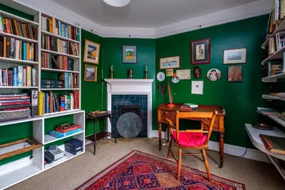 a green room with a desk and a fireplace at Beach House - Aldeburgh Coastal Cottages in Aldeburgh