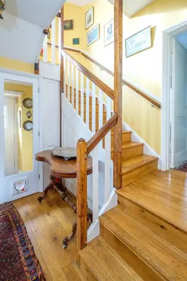 a wooden staircase in a home with a wooden table at Beach House - Aldeburgh Coastal Cottages in Aldeburgh