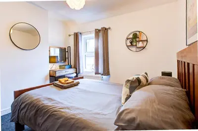 a bedroom with a bed with a mirror and a window at Free Parking Business Stay Office Fast WiFi in Colchester