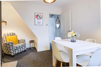 a dining room with a white table and a chair at Free Parking Business Stay Office Fast WiFi in Colchester
