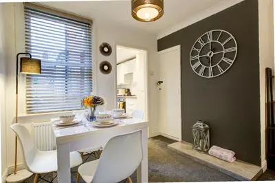 a dining room with a table and a clock on the wall at Free Parking Business Stay Office Fast WiFi in Colchester