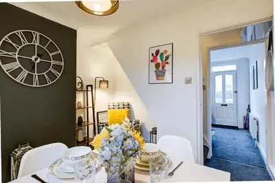 a dining room with a table and a clock on the wall at Free Parking Business Stay Office Fast WiFi in Colchester