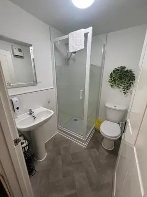 a bathroom with a shower and a toilet and a sink at Mayland Motel in Mayland