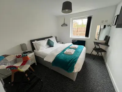 a bedroom with a bed and a chair and a window at Mayland Motel in Mayland