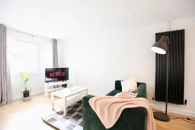 a living room with a green couch and a table at Stylish Cambridge City Pad in Chesterton