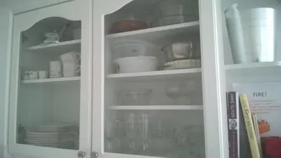 a white cabinet filled with dishes and plates at Chauffeur's, Snape in Saxmundham