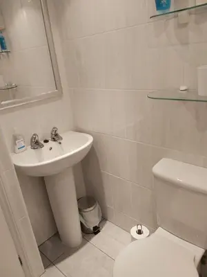 a white bathroom with a sink and a toilet at Chauffeur's, Snape in Saxmundham