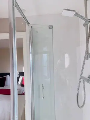 a shower with a glass door in a bathroom at Starview Apartment 101 in Colchester
