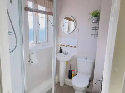 a white bathroom with a toilet and a sink at Starview Apartment 101 in Colchester