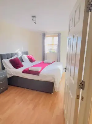 a bedroom with a large bed with red pillows at Starview Apartment 101 in Colchester