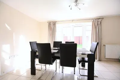 a dining room with a table and black chairs at Large Stylish Cambridge House (4BR/Free Parking) in Cambridge