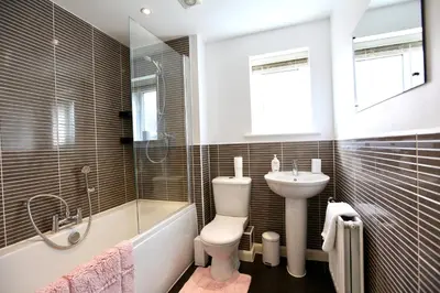 a bathroom with a toilet and a sink and a tub at Large Stylish Cambridge House (4BR/Free Parking) in Cambridge