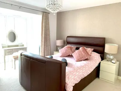 a bedroom with a bed with pink pillows on it at Large Stylish Cambridge House (4BR/Free Parking) in Cambridge