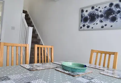 a dining room table with a green bowl on it at Station Heights in Rayleigh