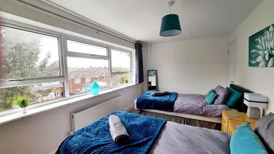 a bedroom with two beds and a window at Station Heights in Rayleigh