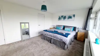 a bedroom with a bed with blue pillows at Station Heights in Rayleigh