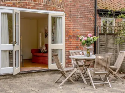 a patio with a table and chairs and a couch at Coach House - Uk33307 in Mellis