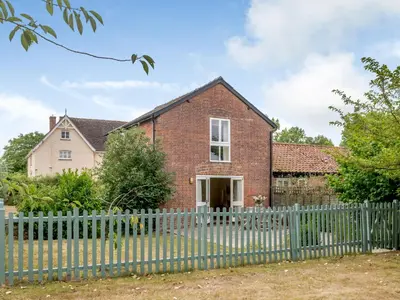 a brick house with a fence in front of it at Coach House - Uk33307 in Mellis