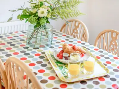 a table with a plate of food and a vase with flowers at Coach House - Uk33307 in Mellis