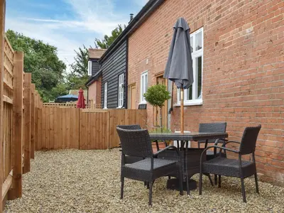 a patio with a table and chairs and an umbrella at Roe Cottage - Uk33490 in Hadleigh