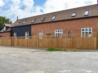 a brick building with a wooden fence in front of it at Roe Cottage - Uk33490 in Hadleigh