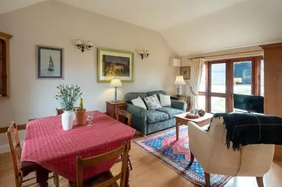 a living room with a table and a couch at The Stables, Theberton in Theberton