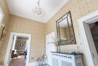 a room with a chandelier and a mirror on the wall at Reymerston Hall in Norwich