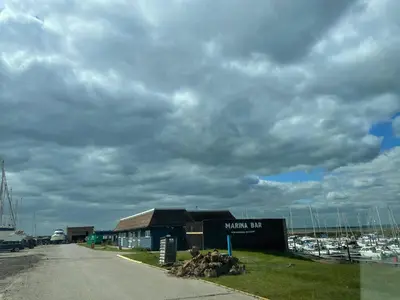 a view of a marina with a building and boats at The Cow Shed - Sleeps 4 Parking & Pet Friendly in Bradwell on Sea